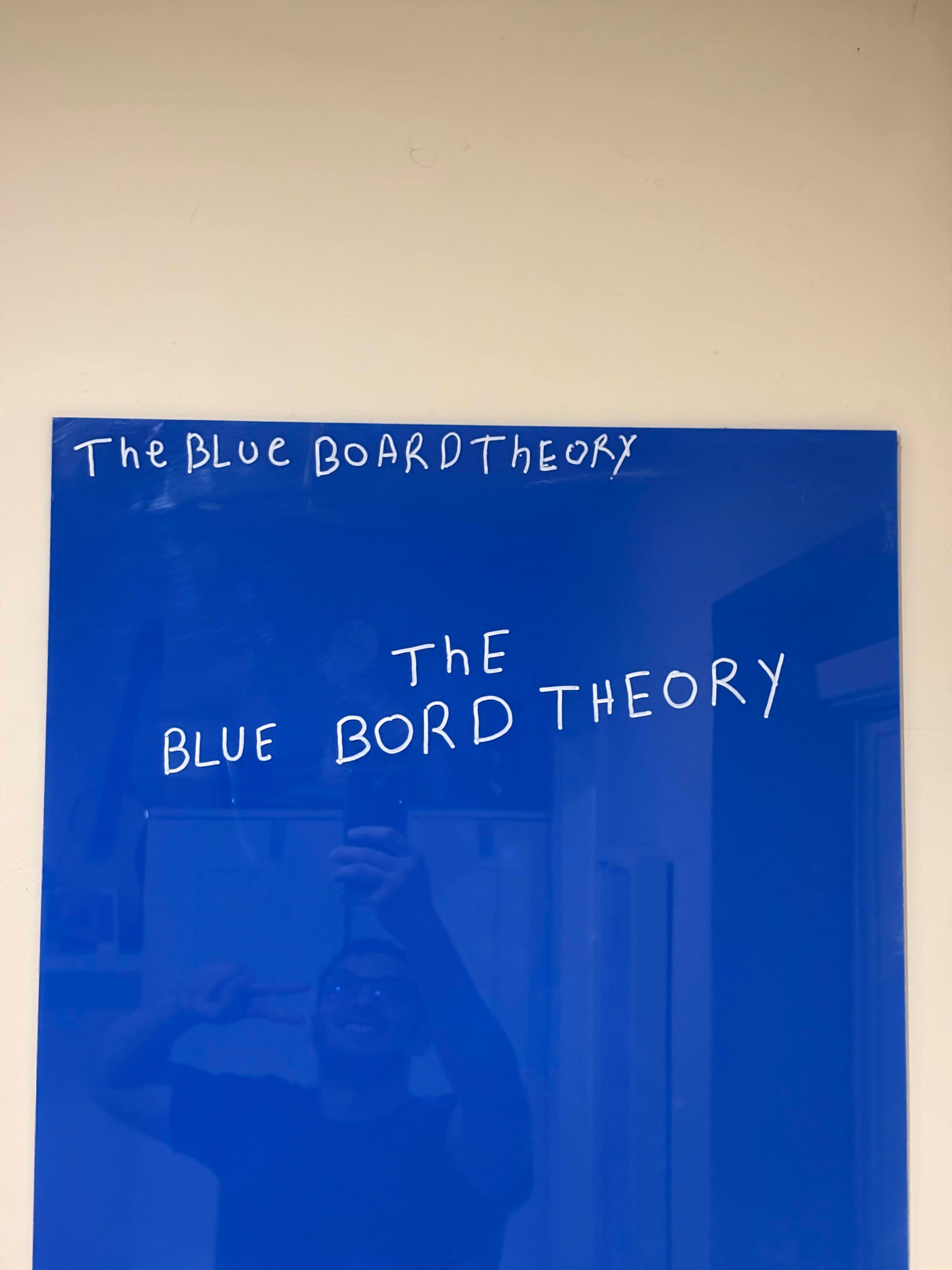 The Blue Board Theory, deep cobalt acrylic board with hand-lettered white marker.